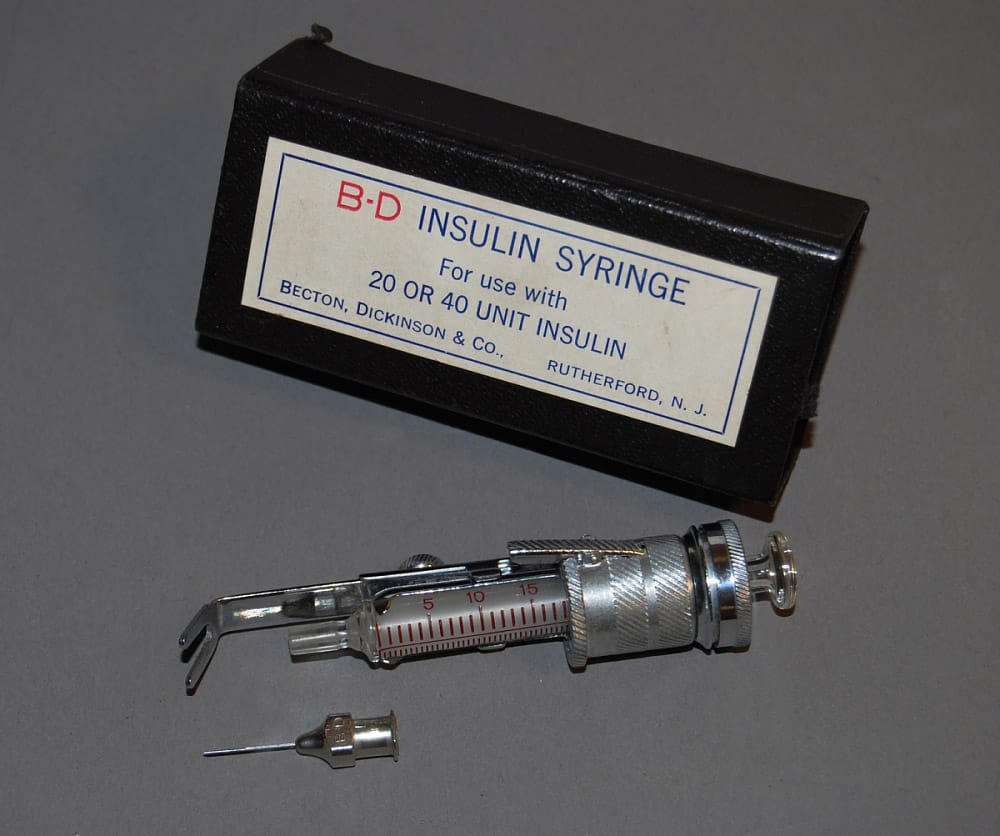 Black box with B-D Insulin Syringe label and large metal syringe with detachable needle.